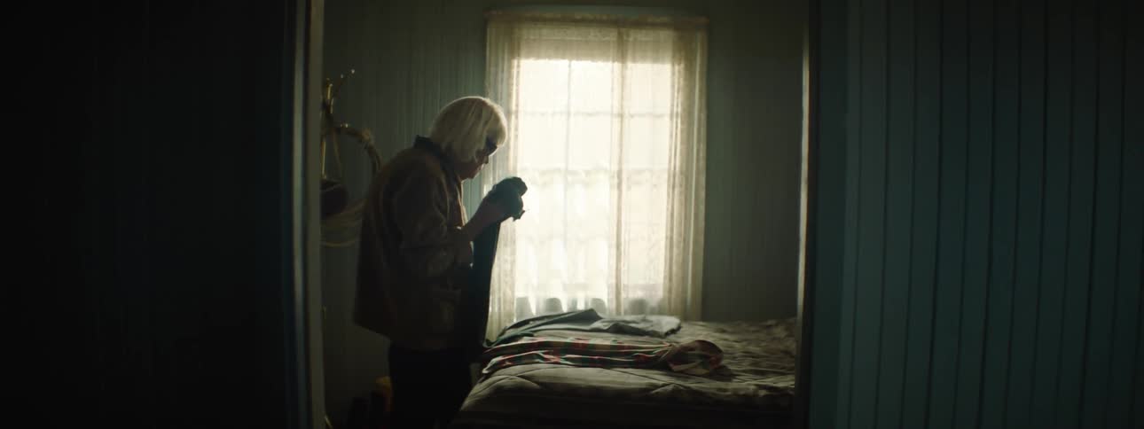 Elderly lady smells clothes in a bedroom