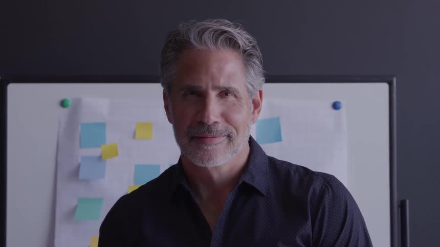 Man standing in front of board with colorful sticky notes in professional planning setting