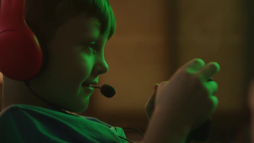 Boy plays video game wearing headphones with a microphone