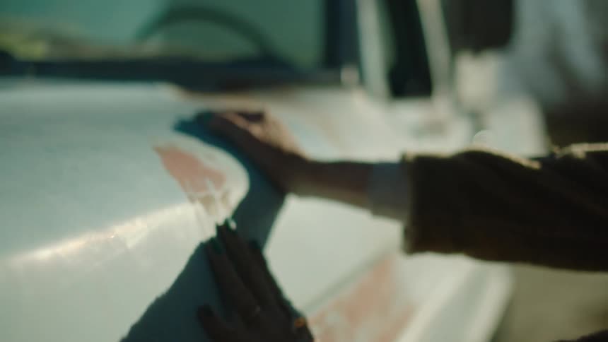 A person touching and rubbing an old beat up truck