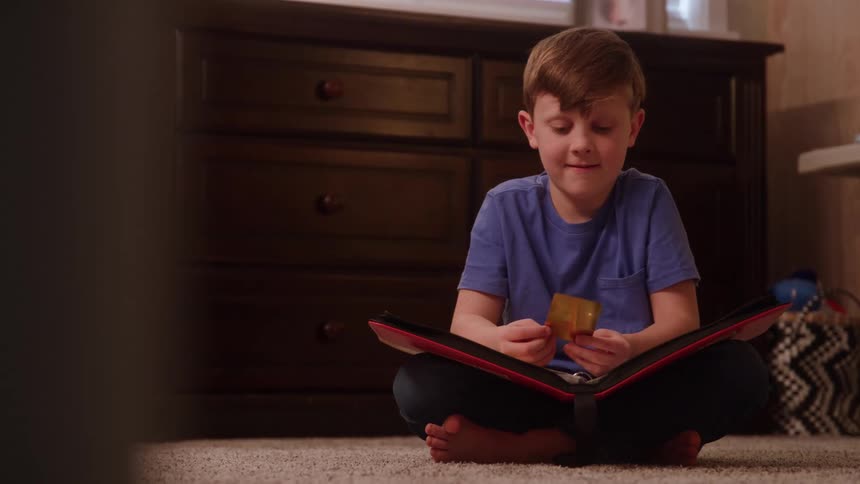 Boy sitting on the floor flips through a photo album