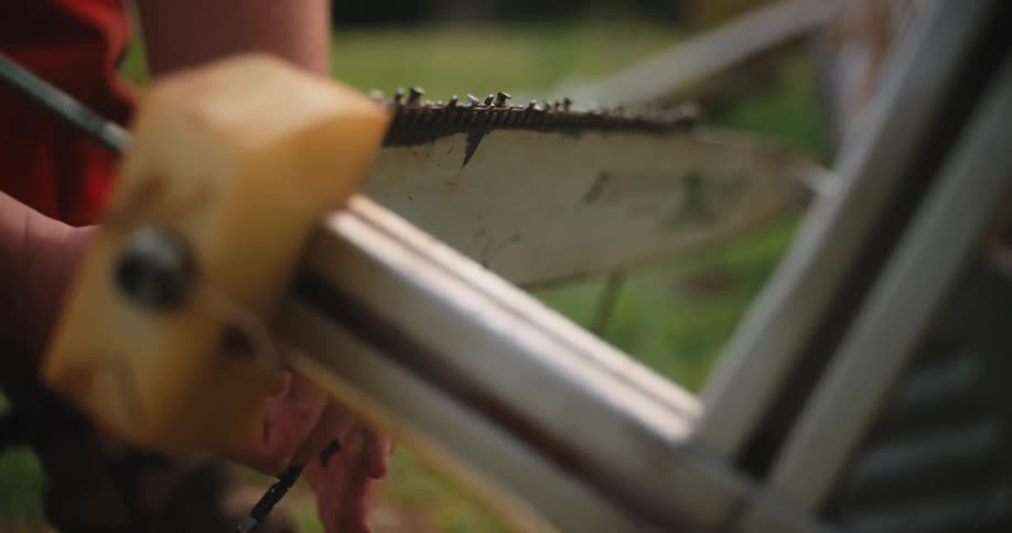 Worker sharpens the blade of a saw outdoors