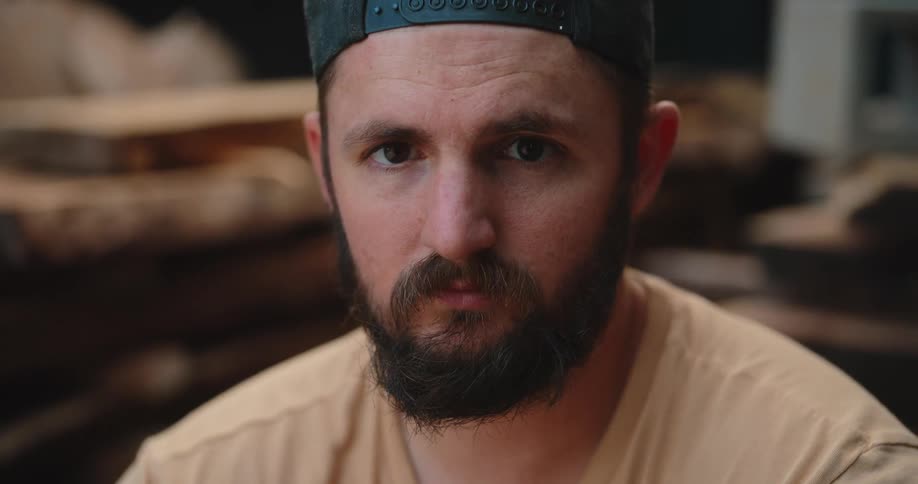Man stares with a serious expression in a woodworking environment