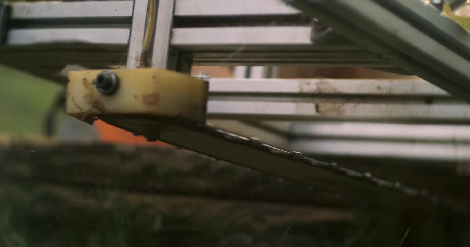 Chainsaw chain moves within a metal frame during cutting