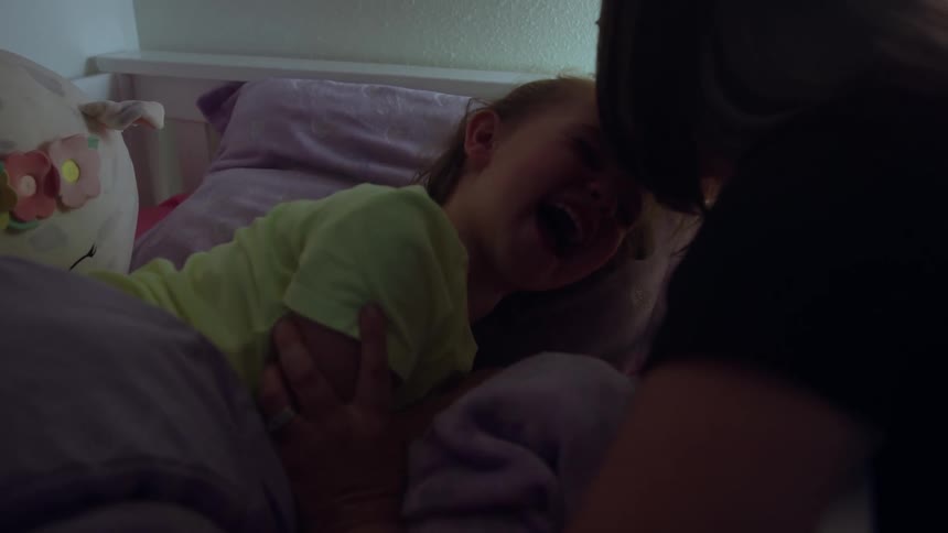 Woman comforts a child about to fall asleep