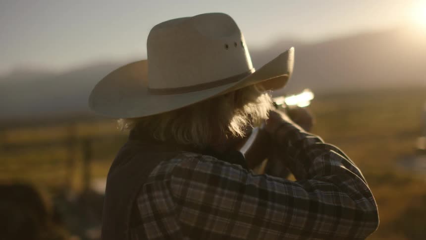 A man holds a rifle to his shoulder and aims