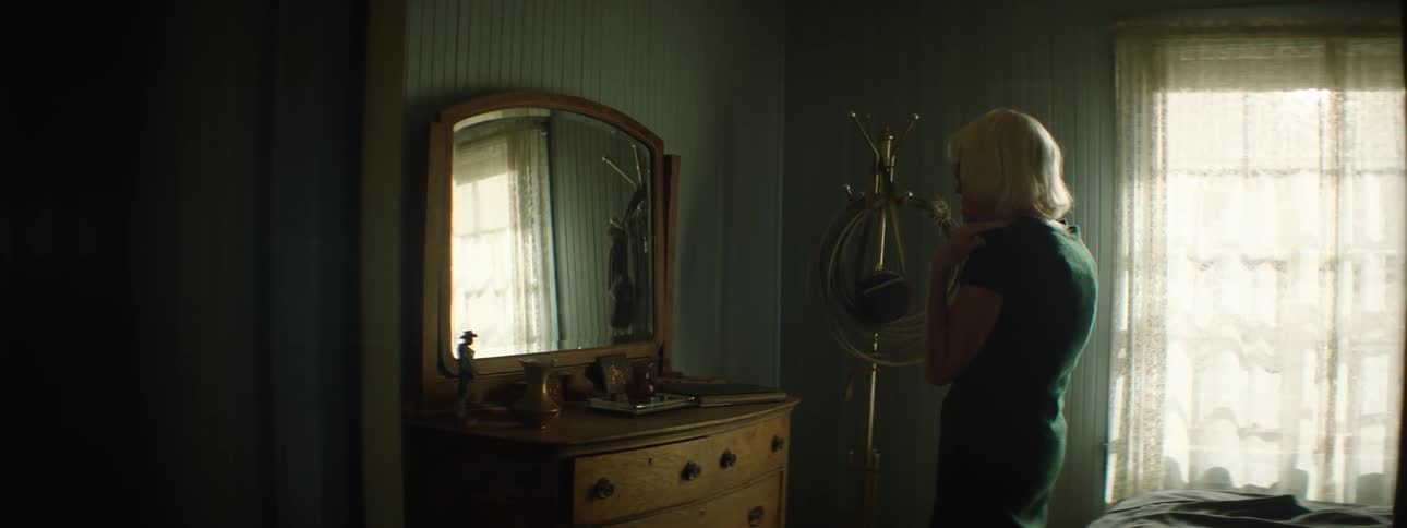A woman gets up looking into a mirror
