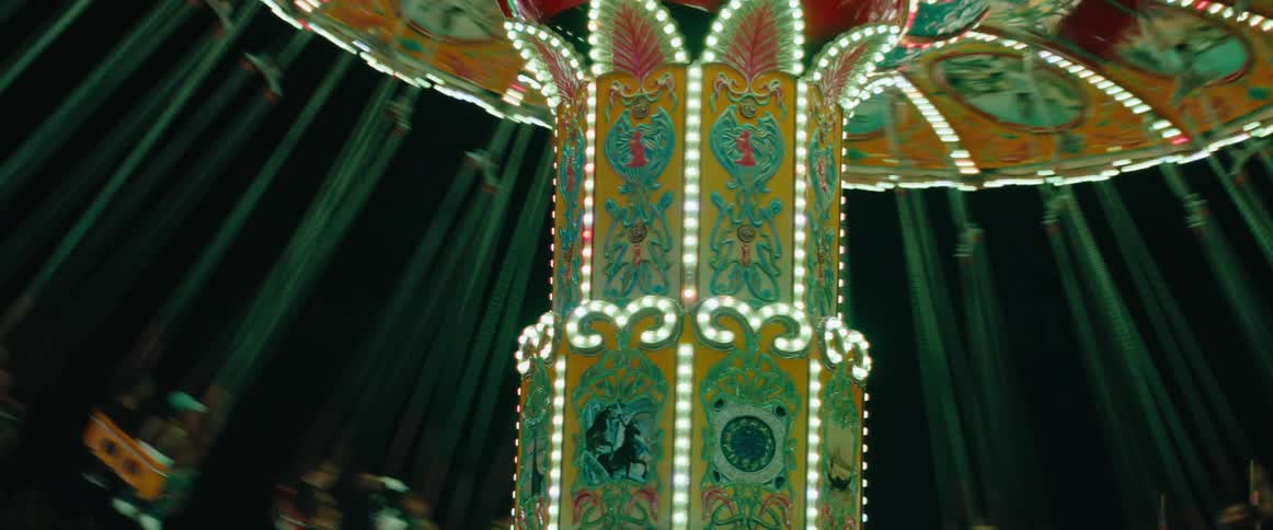 Illuminated carousel spins displaying colorful retro details