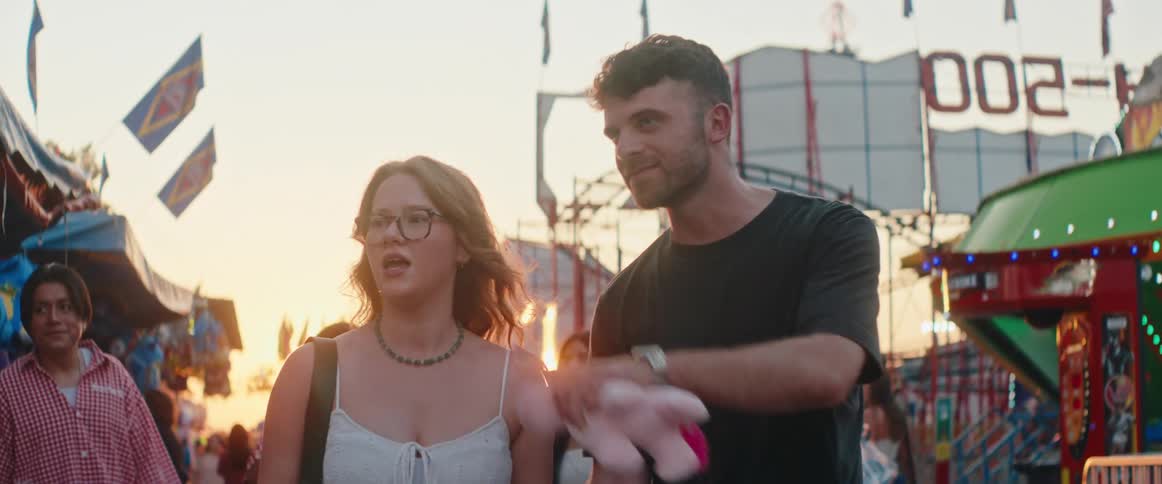 A man and woman walk through a fair