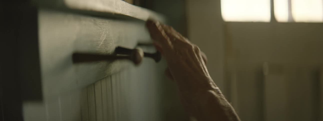 A woman blindly feels along the pegs and top of a shelf