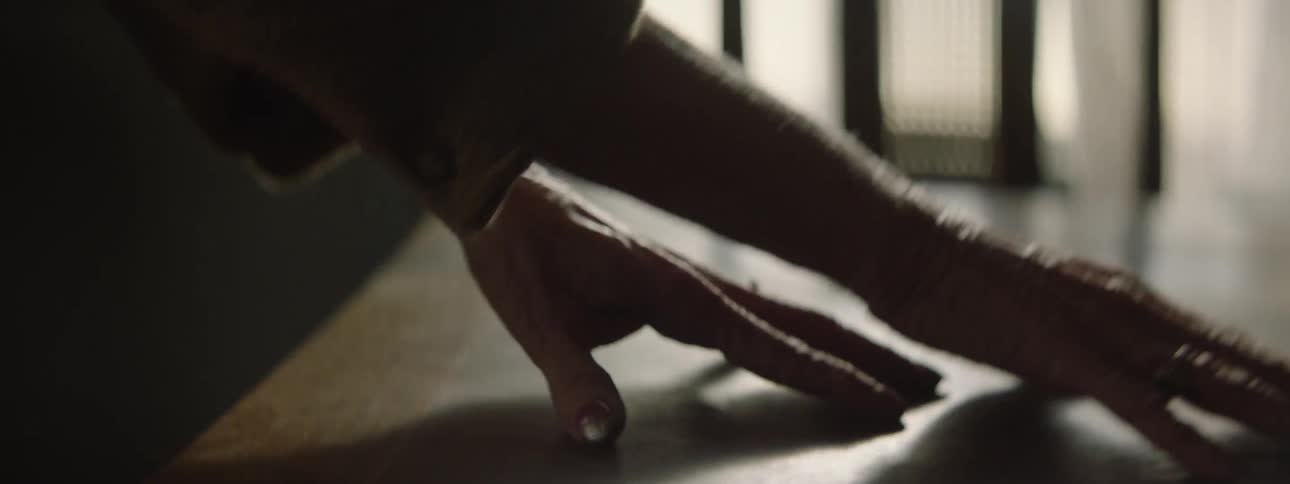 A person traces their fingers on a table