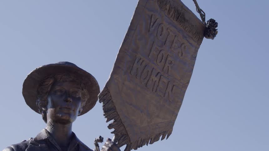 Close up of a living statue holding a flag outdoors during daytime