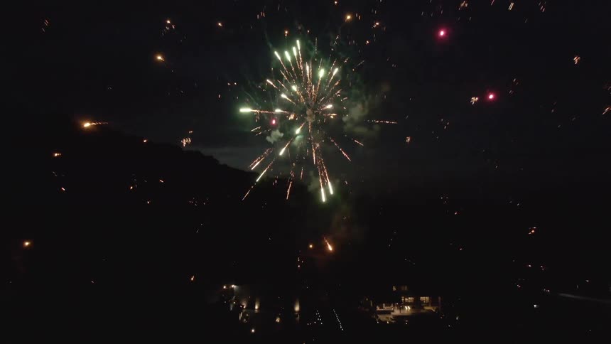 Aerial of colourful fireworks in a metropolitan city sky at night