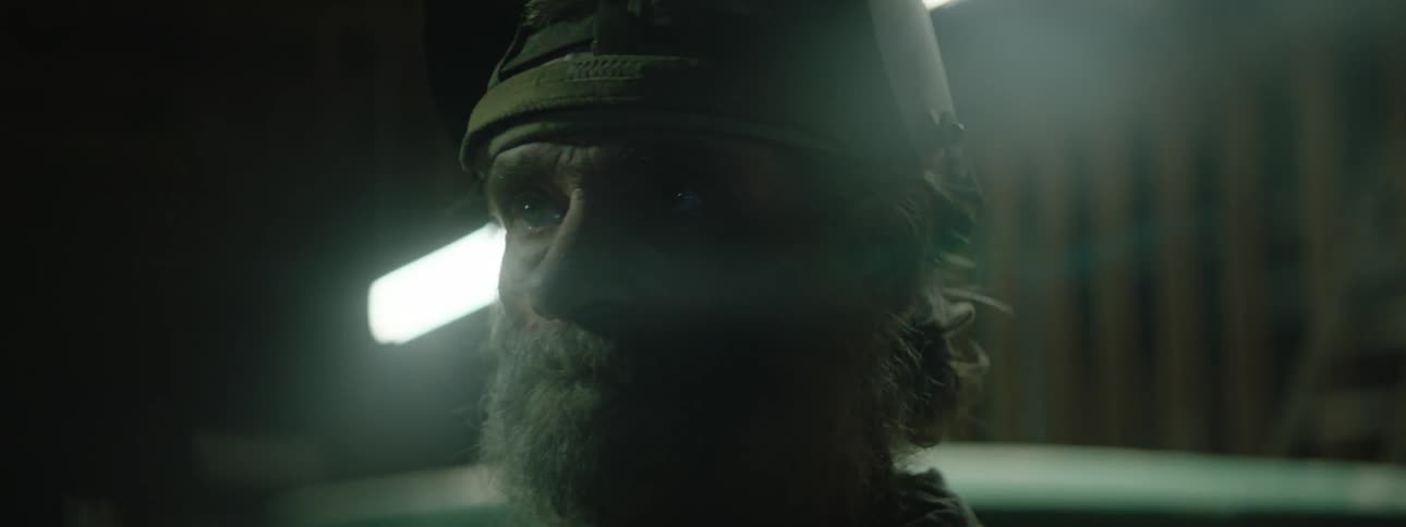 A man wearing a welding helmet looks at the flickering lights