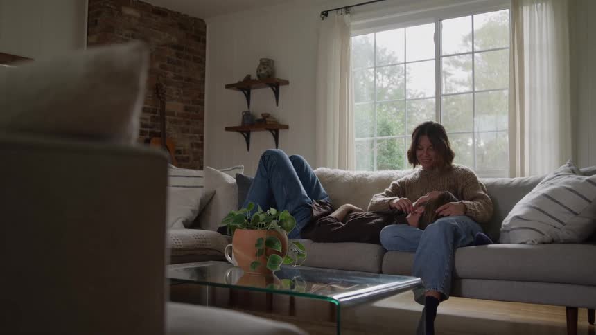A young couple conversing on a couch in a living room during daytime