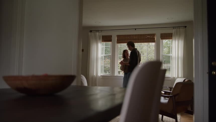 Couple dances slowly in front of a window lit by daylight