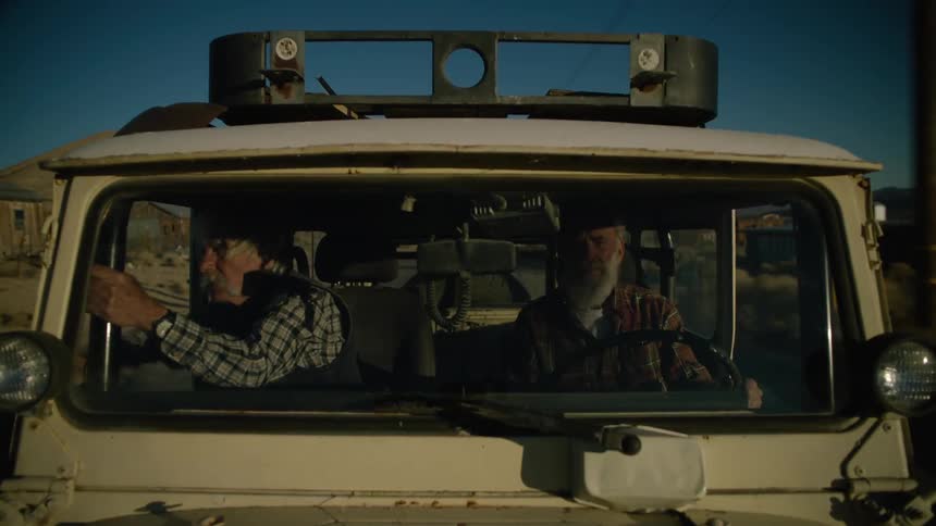 Two elderly men ride in a pickup truck