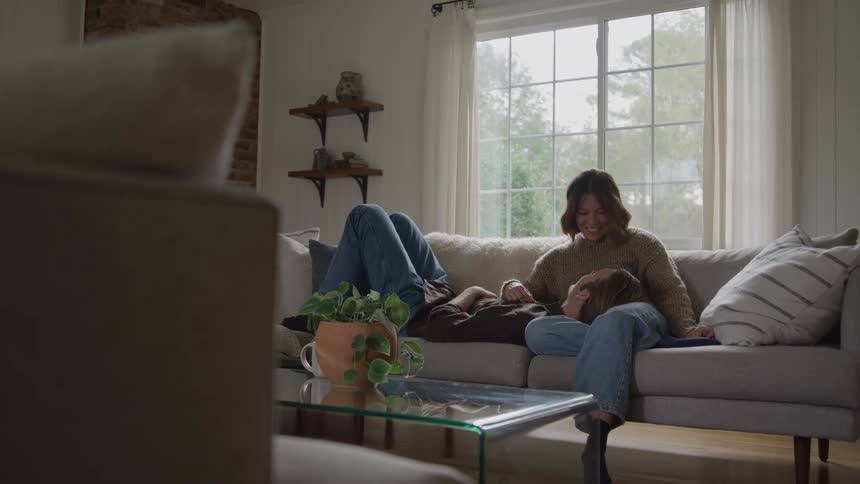 A man lays on a womans lap on the couch