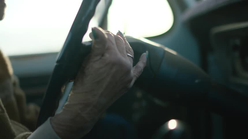 A woman feels along the dash and steering wheel of a truck
