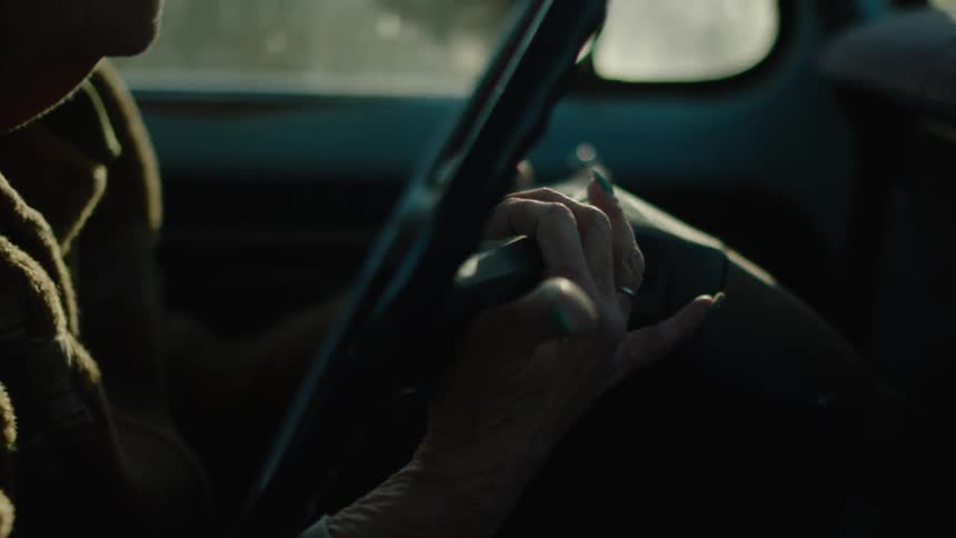 A person is driving a truck feeling around the wheel