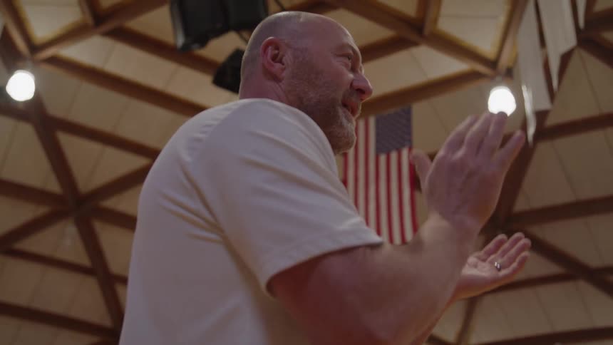 Close up of a male coach clapping and motivating players during an indoor basketball game