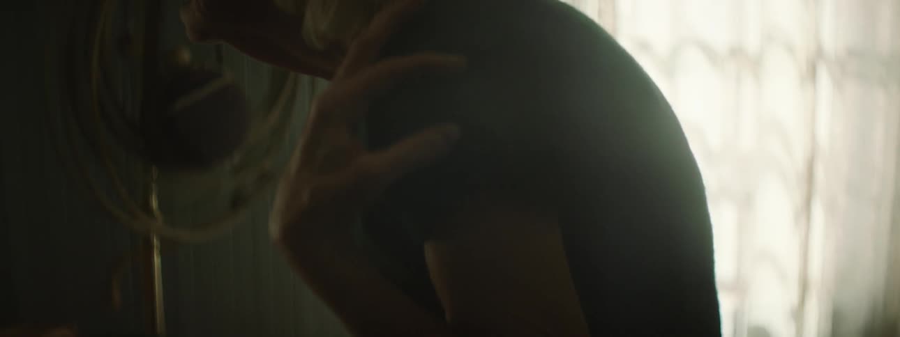 A woman is touching her shoulders and neck with her eyes closed