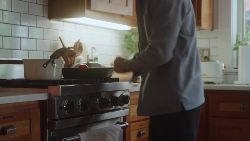 A man prepares a meal in a bright and modern kitchen