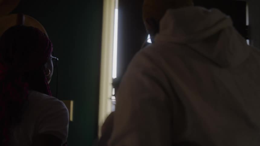 A dark interior shot shows a family hurrying out a front door with a half moon window