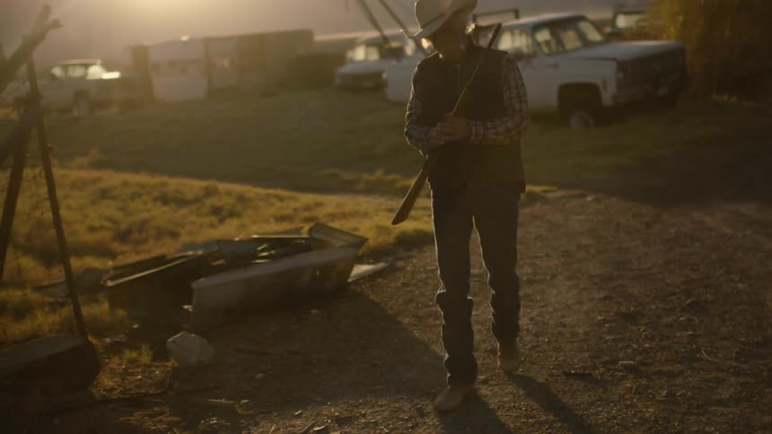 A person walking while carrying a gun