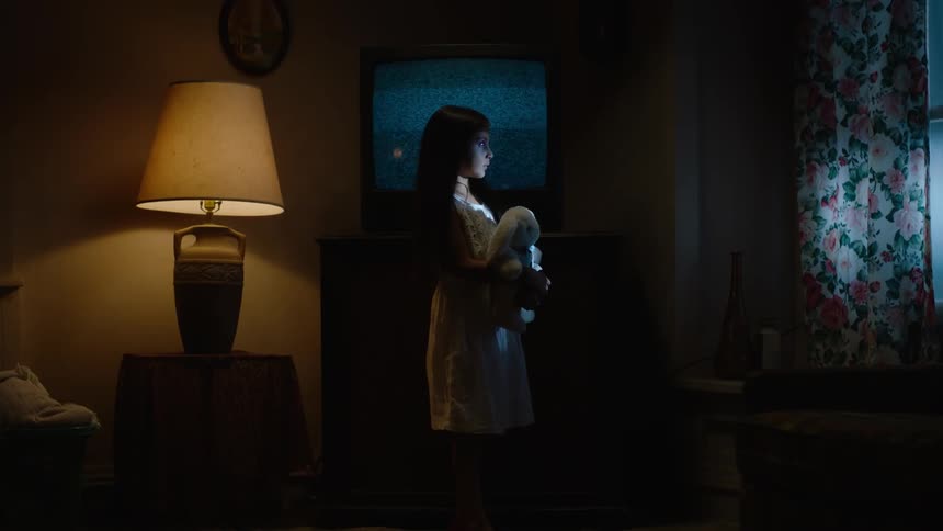 A woman sits by the window looking out