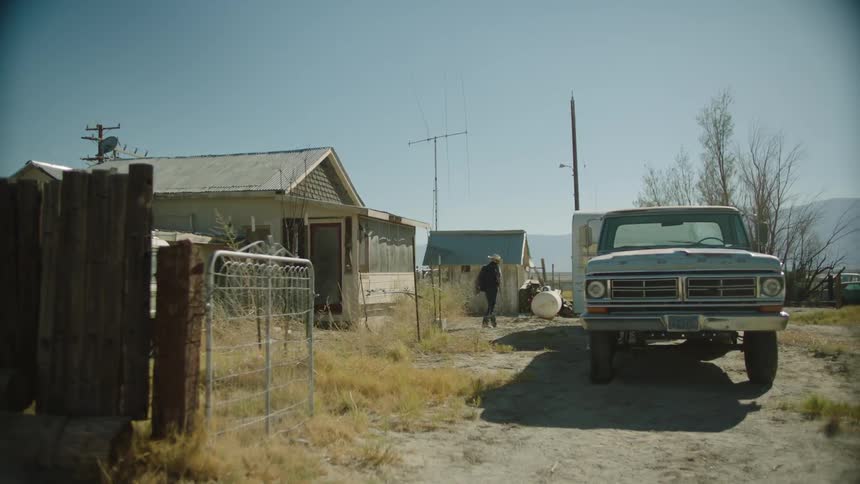 A person walks out from a house towards a truck