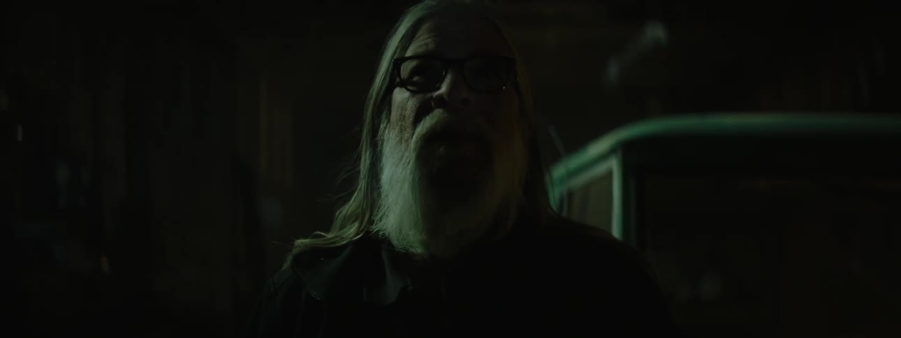 An old man is in a garage looking around as the lights flash on and off