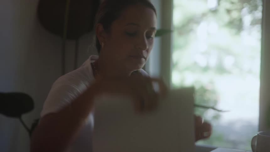 The woman flips through a stack of bills