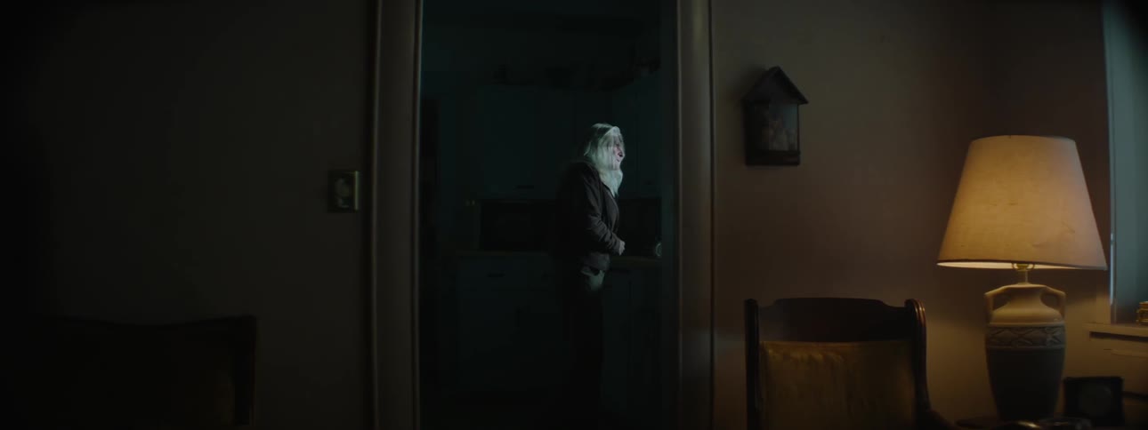 An elder woman looking around  and looking out the windows