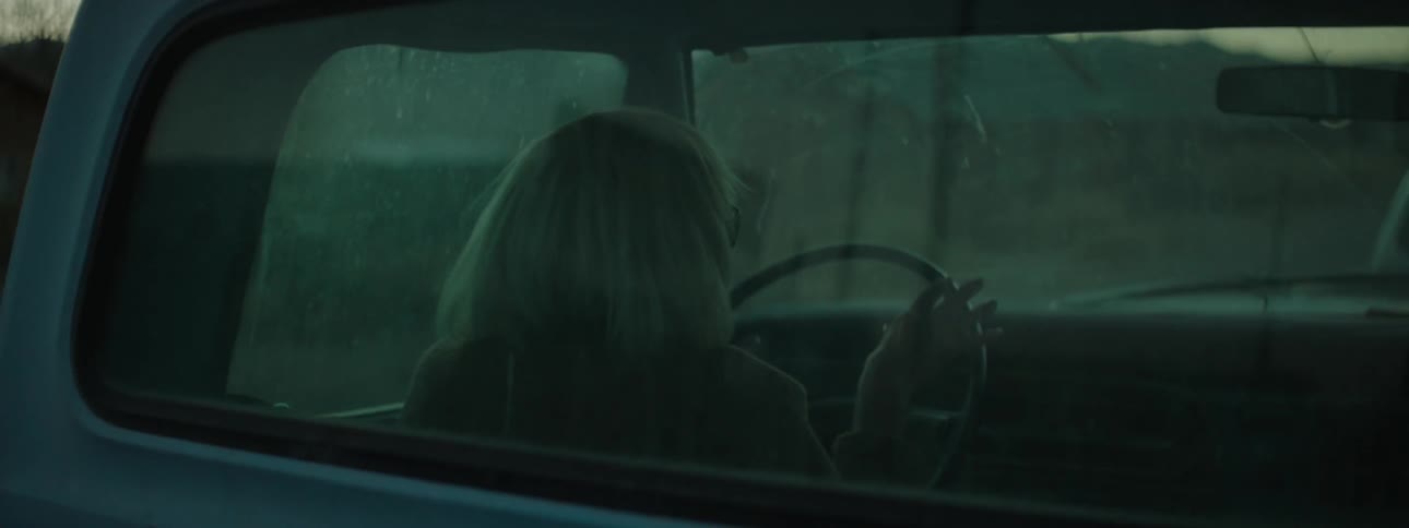 An old woman drives a pickup truck