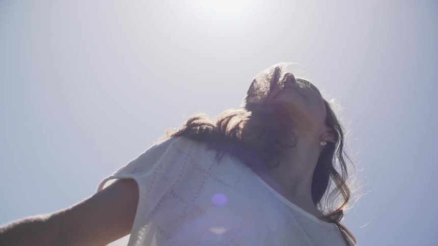 Woman turns around under the shining sun