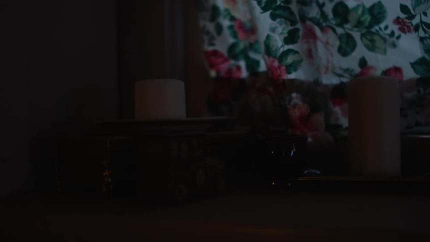 A view of  an unlit candle on a plate next to a chair in a room