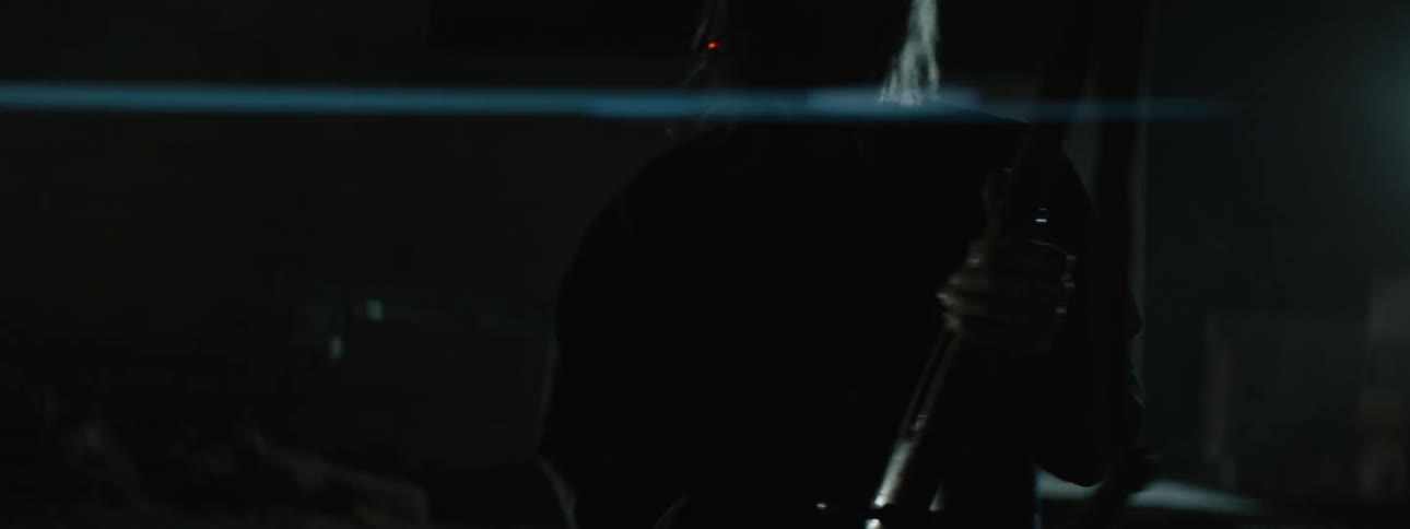 Man outside at night smoking cigarette and holding rifle