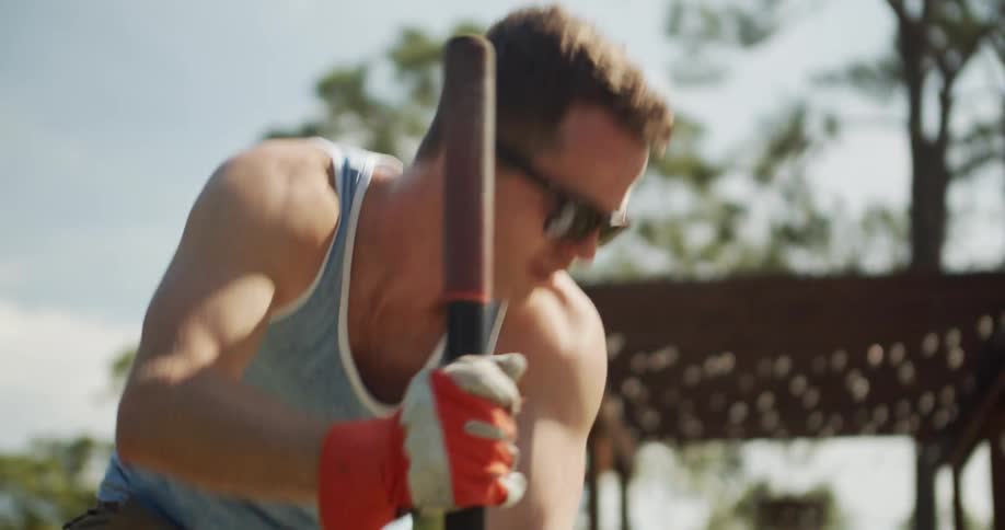 Close up of a young man working with a tool on a field outdoors during daytime