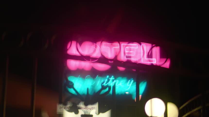 A view of a motel sign up close through a window