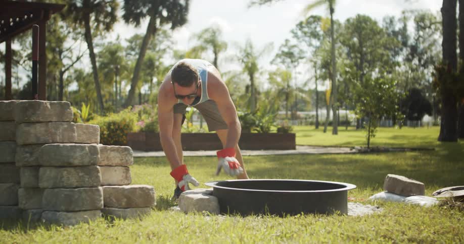 Man assembling a circular structure on the lawn on a sunny day