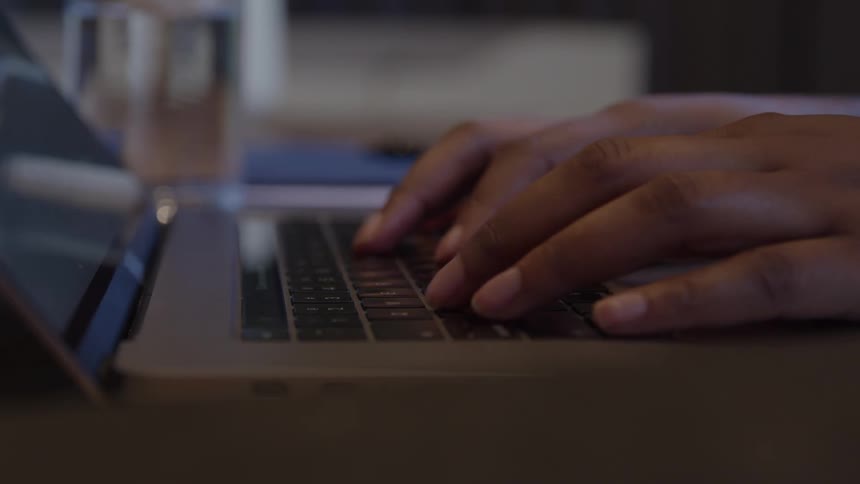 A person types on a laptop