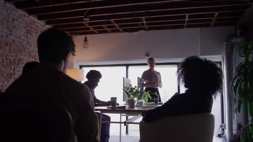 Woman presents a proposal to colleagues during a team meeting in the office