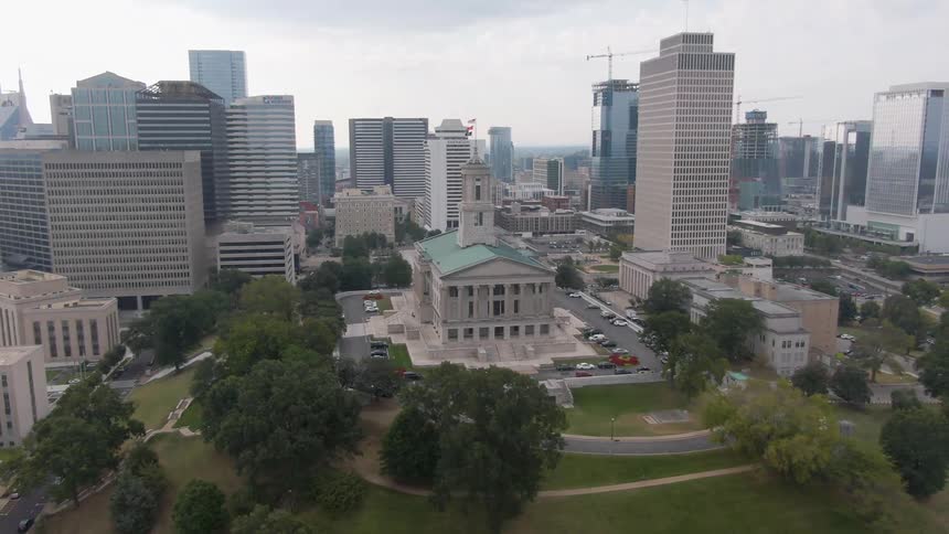 Aerial view highlights tennessee state capitol surrounded by modern and historic buildings in downtown nashville
