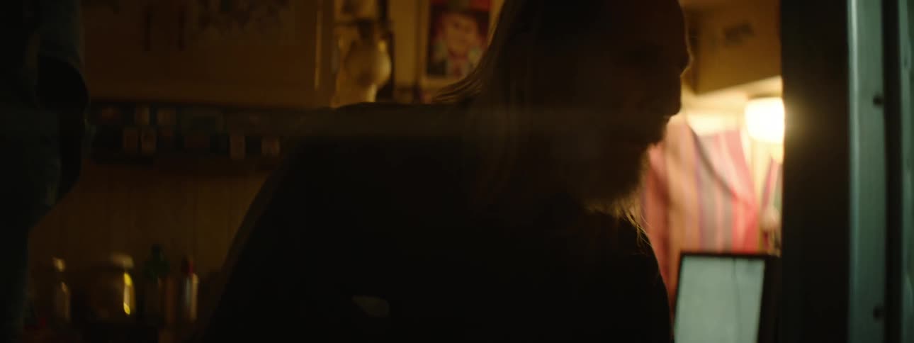 A man gets up from the table grabs a rifle and looks outside