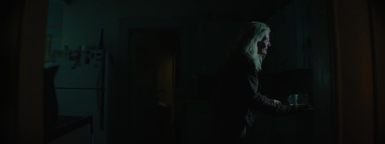 An elder woman looking around in her dark house