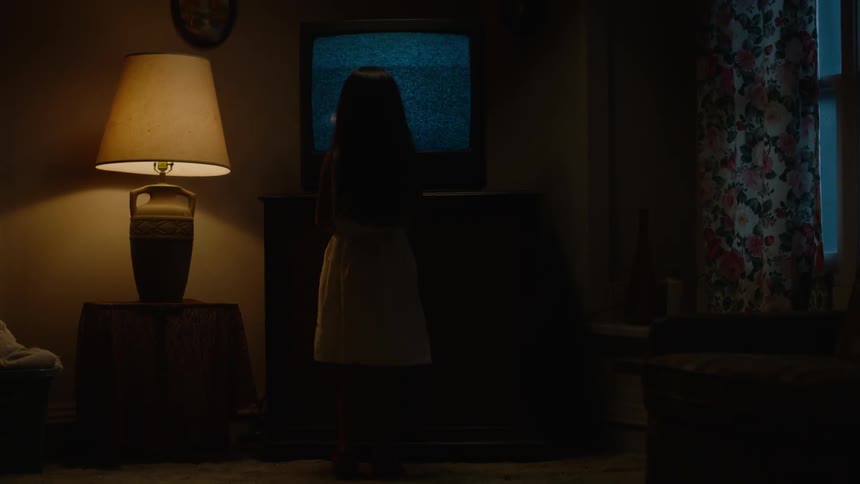 A girl tries to fix a television that is showing static