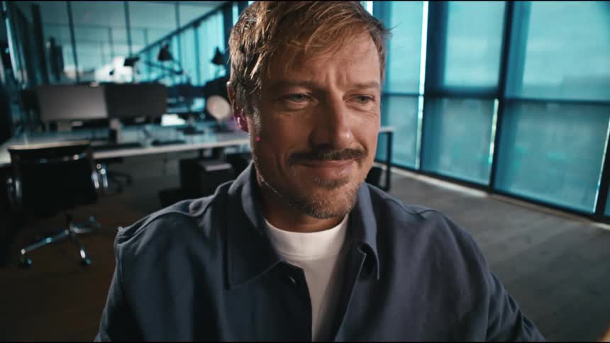 a blonde surfer style office worker happily finishes his presentation