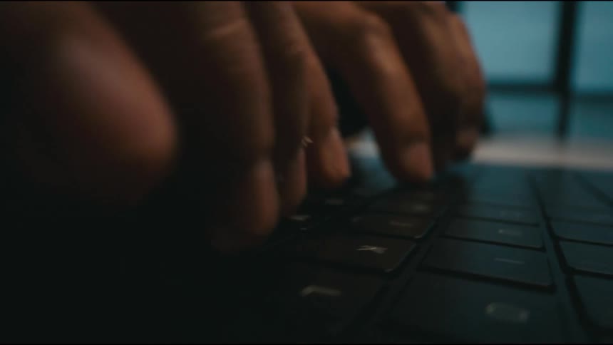 closeup shot of hands typing on a laptop keyboard