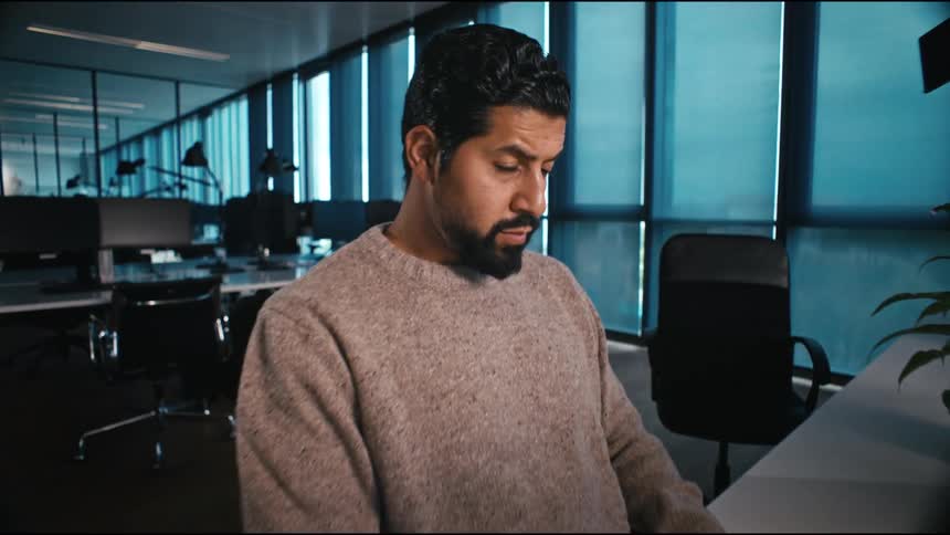 A  man is motivated at work, typing on his keyboard in the office